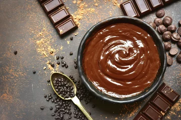 Poster Chocolate ganache in a black bowl with ingredients for making.Top view. © lilechka75