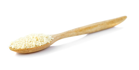 white sesame seeds in wooden spoon on white background