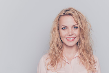 Fototapeta premium Portrait of young attractive nice cute caucasian smiling curly-haired blonde girl wearing casual shirt. Isolated over grey background
