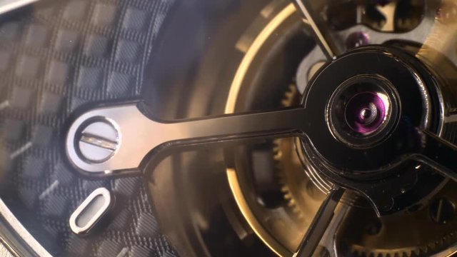 Mechanism of a watch with jewels. Open clockwork and fragments of shiny gears. Close up 4k macro shot. Time and work concept.