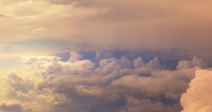 Dreamlike view of white clouds in high sky at golden sunset. Aerial cloudscape panorama