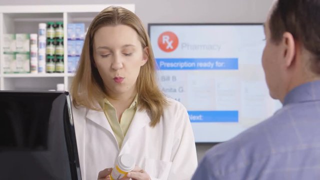 Pharmacist giving prescription instructions to her client