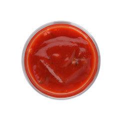 Glass of spicy chili sauce on white background, top view