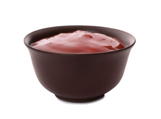 Bowl of spicy chili sauce on white background