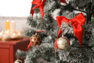 Festive decorations on Christmas tree in stylish living room interior