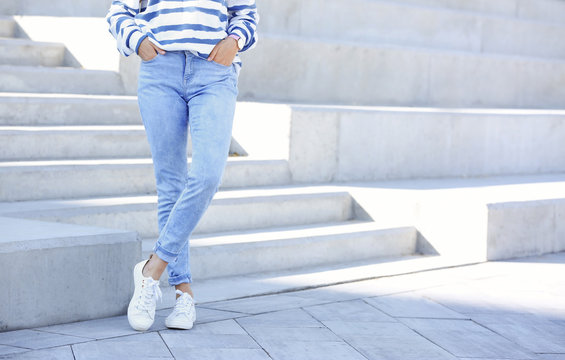 Young Hipster Woman In Stylish Jeans Standing Near Stairs Outdoors