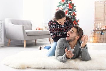 Happy young couple celebrating Christmas at home