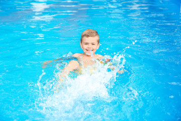 Fototapeta na wymiar Little boy in swimming pool on sunny day