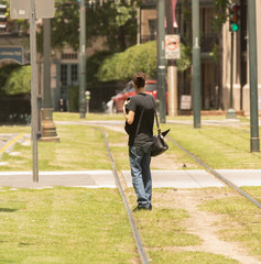 unknown woman looking down the tracks for the next trolley