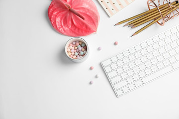Creative flat lay composition with tropical flower, stationery and computer keyboard on white background