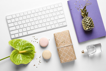 Creative flat lay composition with tropical flower, gift box and computer keyboard on white background