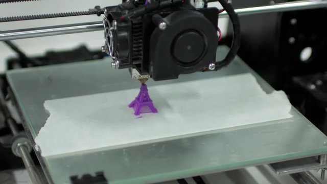 3d printer prints an purple eiffel tower