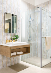 Spacious and bright modern bathroom interior with white walls, a shower cabin with glass wall, a...