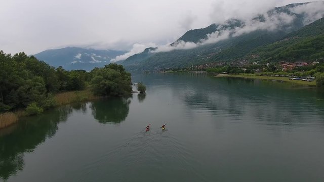 Drone shot of two people in kayaks on a river in sorico (italy).