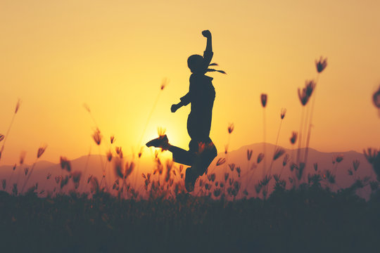 Freedom and sucess - woman happy at meadow . Free cheering girl with arms raised enjoying serene sunset in winning pose with arms stretched.