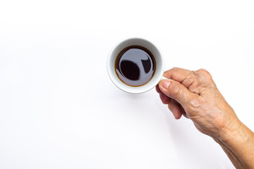 Senior woman's right hand holding black coffee cup isolated on white background
