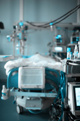 Blurred view of the modern equipped intensive care ward with comatose patient in the bed.
