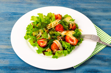 Salad with strawberries, cheese, green leaves, walnut