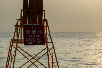 Lifeguard chair on beach at sunset in New York