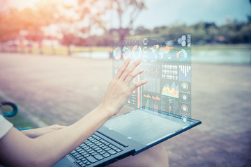 Businesswoman hand using advance technology computer hologram air screen display projection business information data chart outdoor for decision support system