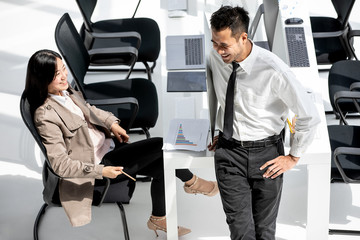 Two Asian businessmen, man and woman taking with happiness in modern office. One people stading and...