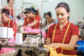 Seamstress in textile factory sewing using industrial sewing mac