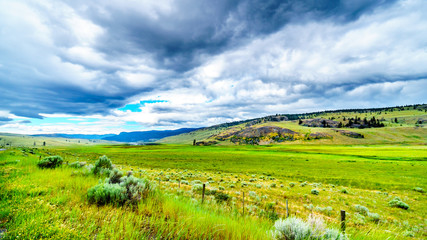 Fototapeta na wymiar Dark Clouds hanging over the fertile farmland and rolling hills along Highway 5A near Nicola Lake, between Kamloops and Merritt in the Okanagen region of British Columbia, Canada