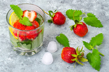 Cold summer drink with strawberries, lemon and mint