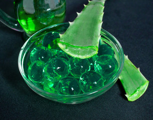 Still life. Natural cosmetics from aloe vera, oils and gel on a black background. Everything for the skin.