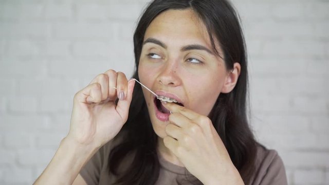 Dental floss. Portrait of girl. Teeth cleaning, braces.