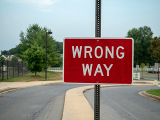 Wrong way red sign at a local neighborhood driveway with space to the left