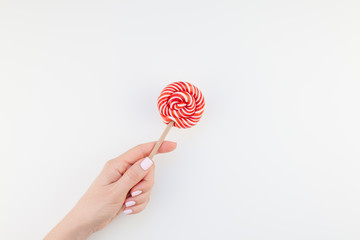 Woman hand with red lollipop