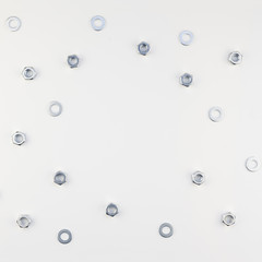 Flat lay of metal nuts on white background