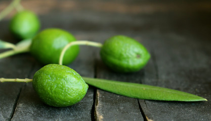 Fresh green olives isolated on wood background close up.Blurred background.