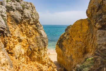 Fototapeta na wymiar Beach paradise view. Yellow sand and Rocks in the Algarve, Portugal. Nice sunbeam and shadow.