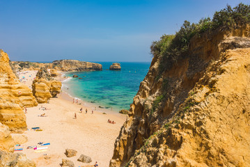 Beach paradise view. Yellow sand and Rocks in the Algarve, Portugal. Nice sunbeam and shadow.