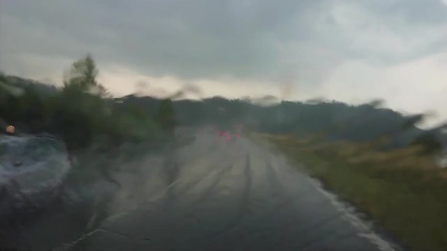 car driving during rain with lights of oncoming vehicles