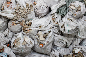 Many trash bags filled with construction waste. Rubbish left after deconstructing an old building.
