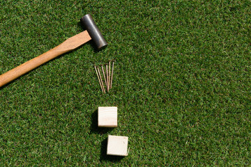 tools(hammer, nail, wood) on turf