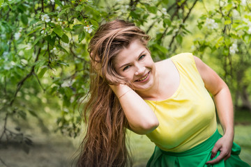 Beautiful young woman near apple tree