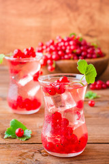 Cold compote with ice cubes from fresh red currant berries. Boiled redcurrant juice.