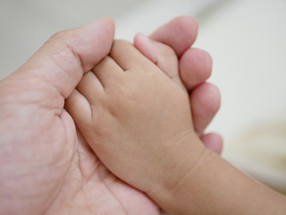 Little baby hand in her father's hand representing father's love, care, and protection