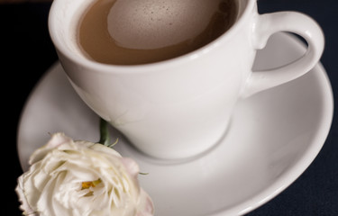 Fototapeta na wymiar black coffee with milk in a white mug with a saucer