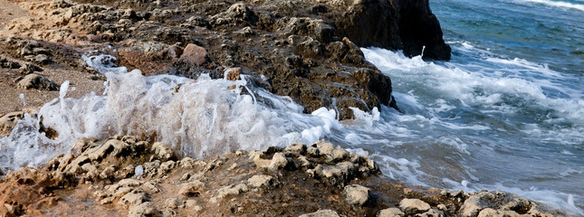 Powerful Waves on a rocky beach. Splits waves against rocks in the sea