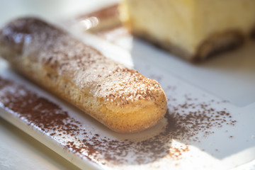 Tiramisu, traditional Italian dessert on a white plate.