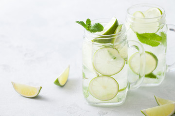 Citrus lemonade water with lime sliced , healthy and detox water drink in summer on concrete table.