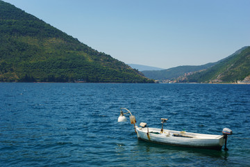 Fototapeta na wymiar Seascape wooden white boat in a bay on a background of mountains.