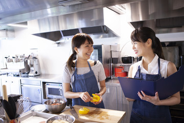 野菜について学ぶ女性が講師と笑顔で会話する風景