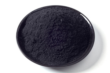Shallow dish of ground activated black charcoal