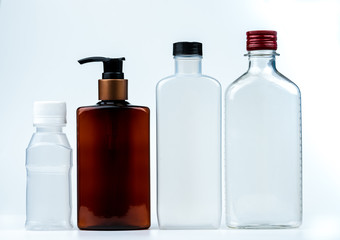 Empty plastic and glass bottle with cap and pump with black label isolated on white background....